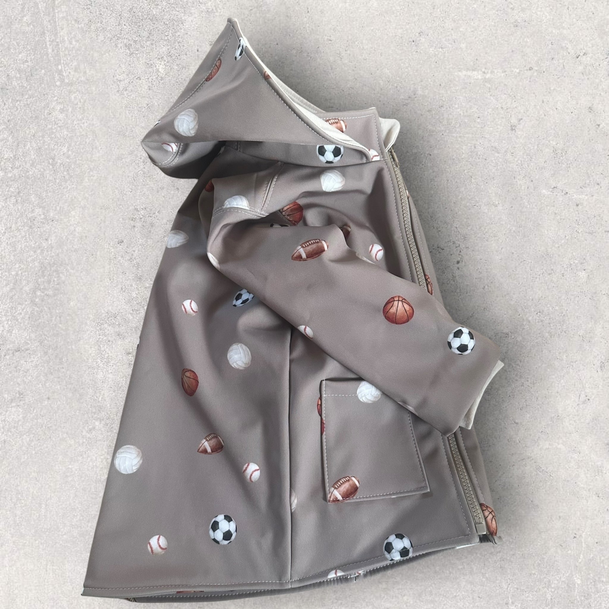 Funktionale Kinder Softshelljacke mit großen aufgesetzten Taschen und elastischen innenliegenden Bündchen im Sport-Design.