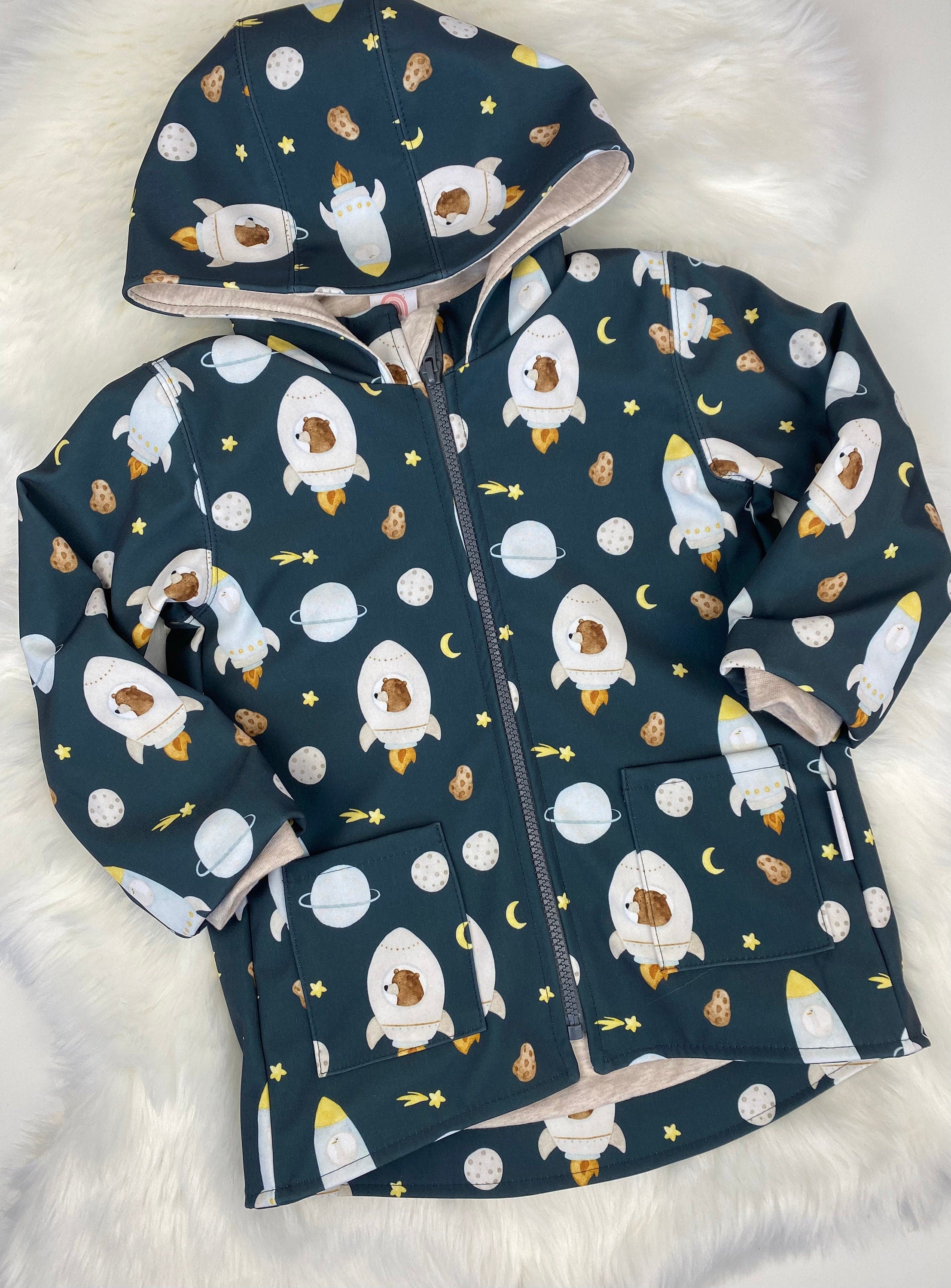 Softshell regenjacke für Kinder mit Kapuze, Kragen und vorne aufgesetzten Taschen in Dunkel blau mit Bären und Raketen
