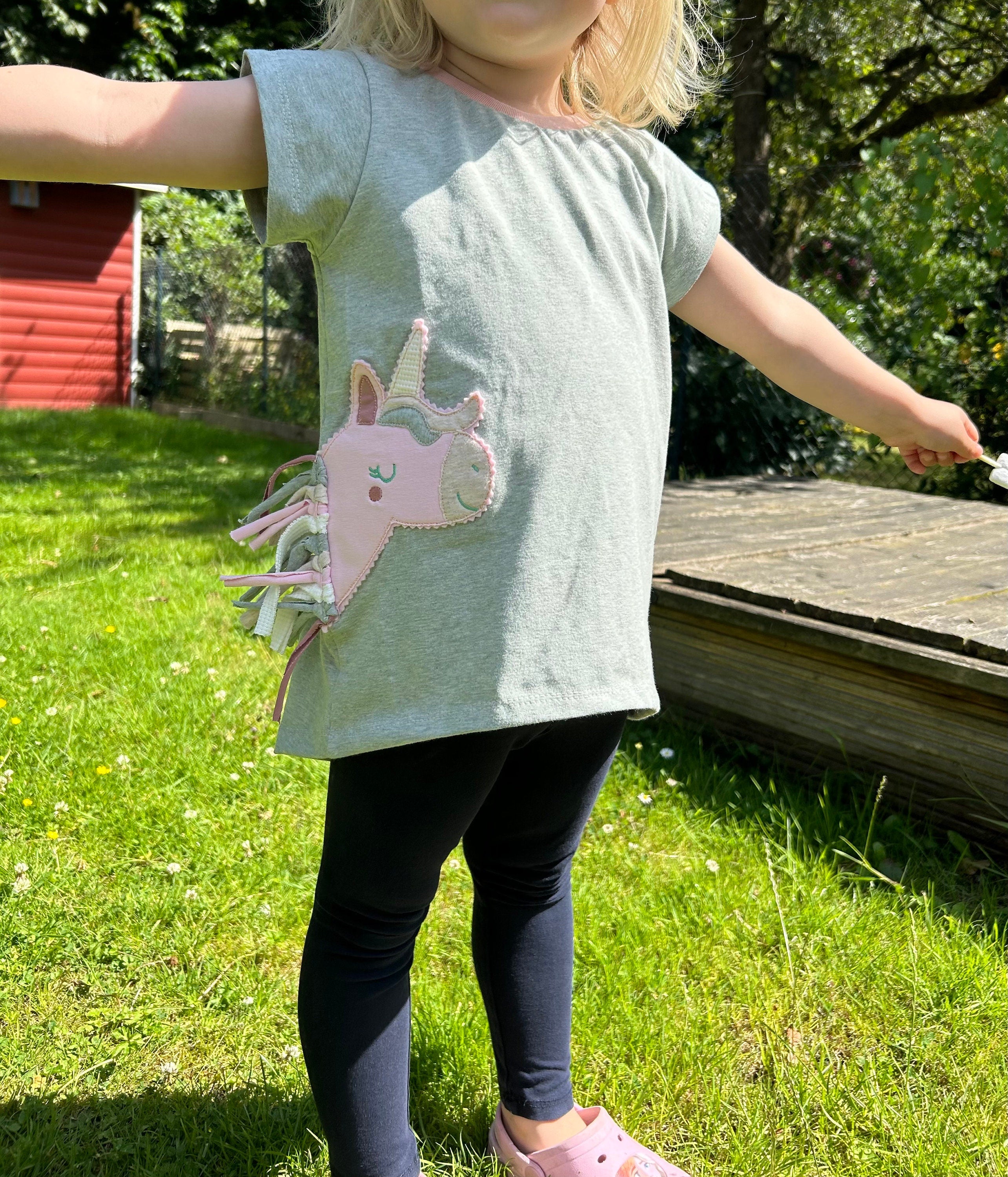 Mädchen mit tollenT Shirt mit gestickter Einhorn Applikationmit Mähne in der Seitennaht.